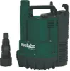 A green and black submersible pump with a black hose adapter next to it, set against a white background. Náhled obrázku produktu