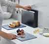 A person is using cutting boards in a kitchen setting. Podgląd zdjęcia produktu