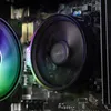 Close-up of a computer's internal components, specifically two fans, one with RGB lighting. Produktbild-Vorschau