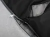 A close-up view of a zipper on a gray fabric item, revealing a black mesh interior. Náhled obrázku produktu