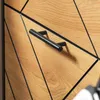 A close-up view of a wooden cabinet with black accents and a black handle. Produktbild-Vorschau