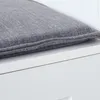 A close-up view of a gray cushion on a white surface. Produktbild-Vorschau