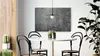 A modern dining area with a round table, chairs, and a large plant. Anteprima dell’immagine prodotto