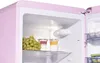 Close-up interior view of a pink refrigerator. Produktbild-Vorschau