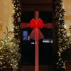 A decorated door with Christmas lights and a large red bow. Náhled obrázku produktu