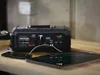 A Noco GB500+ jump starter is shown charging a smartphone and a tablet. Produktbild-Vorschau