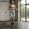 A woman is jumping rope indoors in a modern gym or studio. Produktbild-Vorschau