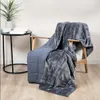 A weighted blanket draped over a chair next to a small side table with a book and a plant. Produktbild-Vorschau