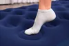 A person's foot in a white sock stepping on a blue inflatable mattress. Náhled obrázku produktu