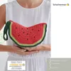 A person holding a crocheted watermelon clutch bag. Produktbild-Vorschau
