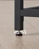 A close-up of a black metal furniture leg with an adjustable foot on a wooden floor. Náhled obrázku produktu