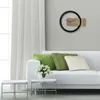 A modern living room with a white sofa, decorative pillows, and a stylish wall clock. Anteprima dell’immagine prodotto
