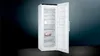 A white upright freezer with its door open, showing multiple transparent drawers inside. A piece of meat is visible in one of the drawers. Anteprima dell’immagine prodotto