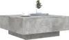 A square coffee table with a concrete finish, a white cup and saucer, and a small potted plant on top. Voir les images du produit