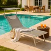 A lounge chair by a swimming pool with drinks on a side table. Produktbild-Vorschau