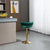A green velvet bar stool with a gold base is shown in a modern kitchen setting. Voir les images du produit