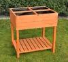 A wooden raised garden bed with four compartments, lined with black fabric, sits on a green lawn. Voir les images du produit