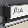 Close-up of a white projector screen with the brand name 'Pantera' and a film reel logo, mounted on a dark wall. Produktbild-Vorschau