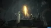 Two figures stand in a dimly lit, cavernous interior, with a bright golden light emanating from a central point. Produktbild-Vorschau