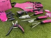 A set of pink and black gardening tools laid out on a green, artificial grass surface. Podgląd zdjęcia produktu