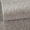 A close-up view of a textured carpet with a woven pattern. Produktbild-Vorschau