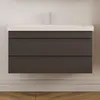 A modern wall-mounted bathroom vanity with a white countertop and two dark gray drawers, set against a plain wall. Produktbild-Vorschau