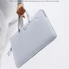 A person is holding a light blue laptop bag. Náhľad obrázku produktu