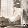 A cozy corner with a hanging chair, lamp, and books. Produktbild-Vorschau