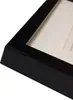 A close-up view of the corner of a black picture frame with a white matting inside. Náhľad obrázku produktu
