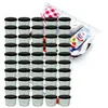 A collection of small glass jars with black lids, arranged in rows, with a small packet of what appears to be dessert mix in the background. Náhled obrázku produktu
