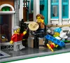 Three Lego minifigures interacting outside a Lego building. Produktbild-Vorschau