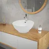 A white ceramic vessel sink on a wooden vanity in a modern bathroom. Náhled obrázku produktu