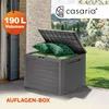 A grey garden storage box with its lid open, filled with green cushions and pillows, placed on a patio with a garden in the background. Produktbild-Vorschau