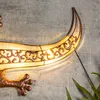 A close-up view of a decorative gecko-shaped wall light mounted on a textured gray wall. Produktbild-Vorschau