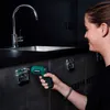 A woman is using a cordless drill to attach a metal bracket to a dark cabinet. Produktbild-Vorschau