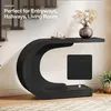A black C-shaped console table with decorative items on top, placed in a hallway setting with stairs in the background. Anteprima dell’immagine prodotto