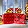 A red wooden advent calendar shaped like a house, open to reveal numbered drawers and a nativity scene inside the roof. Produktbild-Vorschau