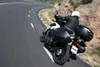 A person riding a motorcycle on a winding road. Produktbild-Vorschau