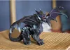 A toy dragon figurine is placed on a woven surface, with a blurred background. Voir les images du produit