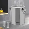 A stainless steel insulated container with steam rising from it, placed on a kitchen counter next to two glasses of water. Náhled obrázku produktu