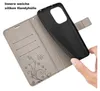 A hand is holding a black phone case, which is being inserted into a gray flip wallet case with card slots and a floral butterfly design. Produktbild-Vorschau