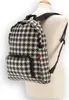 A black and white houndstooth pattern backpack displayed on a mannequin. Produktbild-Vorschau