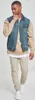 A man is posing for a product shot, wearing a denim vest with tan sleeves over a tan sweatshirt and white t-shirt, paired with tan pants and white sneakers. Produktbild-Vorschau