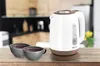A white and brown electric kettle with two cups of coffee on a wooden table in a kitchen setting. Náhľad obrázku produktu