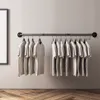 T-shirts on a clothing rack against a plain wall. Produktbild-Vorschau
