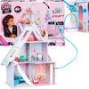 A child looking at the L.O.L. Surprise! OMG Winter Cottage dollhouse packaging, with the dollhouse itself prominently displayed. Produktbild-Vorschau