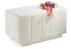 A white bouclé fabric bench with a pink purse and scarf on top, isolated on a white background. Produktbild-Vorschau