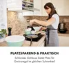 A woman is cooking in a modern kitchen, with the product visible on the counter. Produktbild-Vorschau