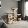 A cat tree is placed in a room with a bed and a window. Náhled obrázku produktu