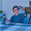 A young boy is playing with two action figures, Batman and another character, on a bed. Produktbild-Vorschau